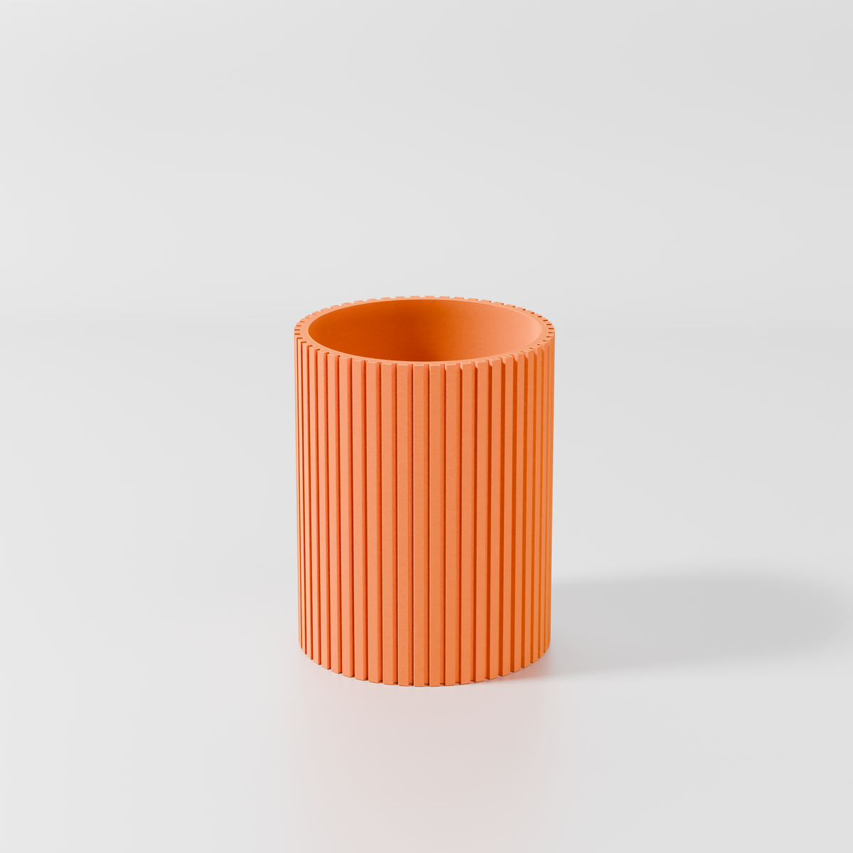 A single, orange cylindrical object with a textured surface, standing alone against a plain white background.