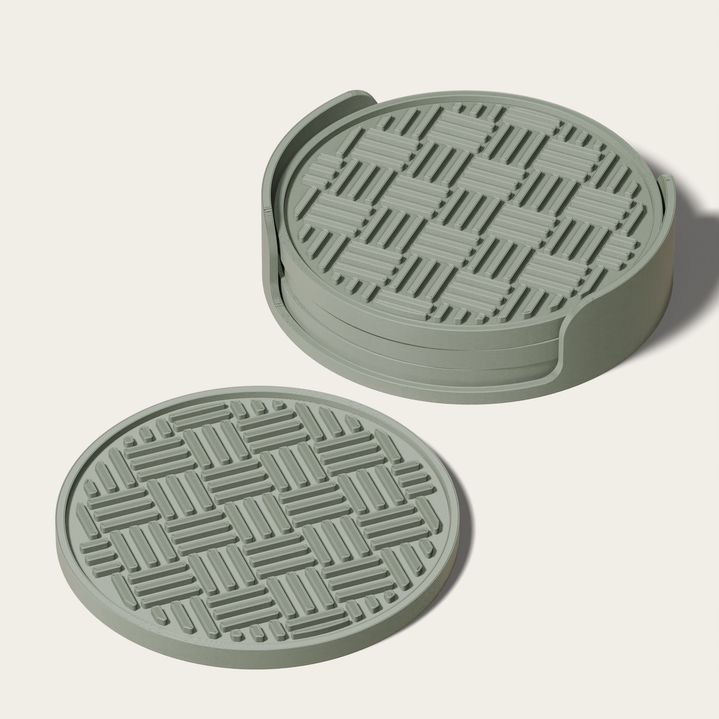 two green coasters with a geometric pattern on them.